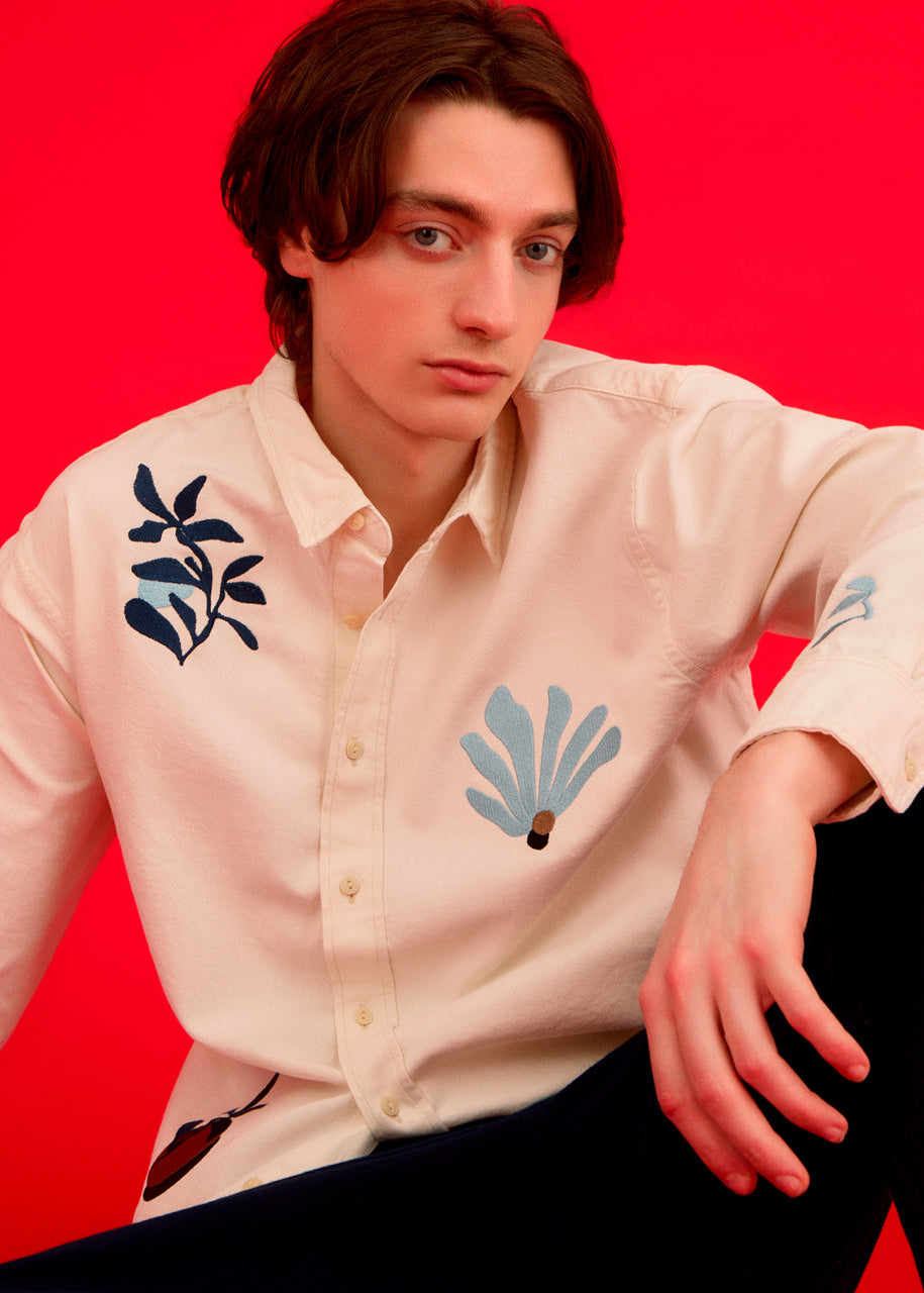 a men wearing an embroidered shirt with abstract floral designs 