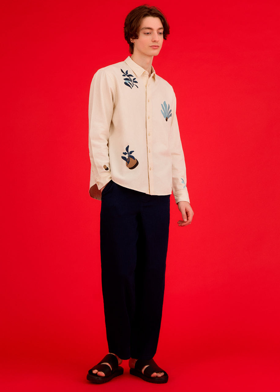 a men wearing an embroidered shirt with abstract floral designs 