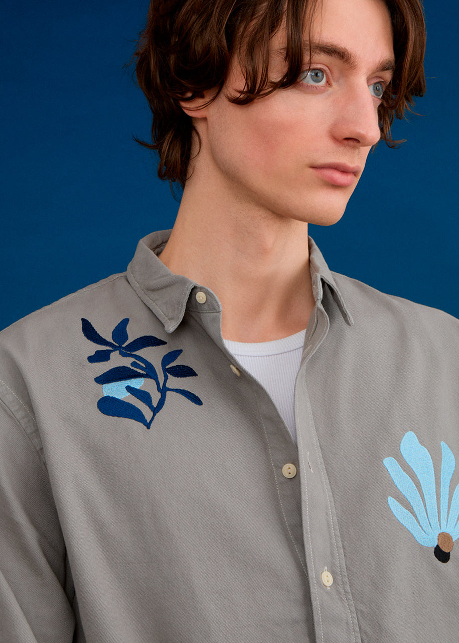 a men wearing an embroidered shirt with abstract floral designs 
