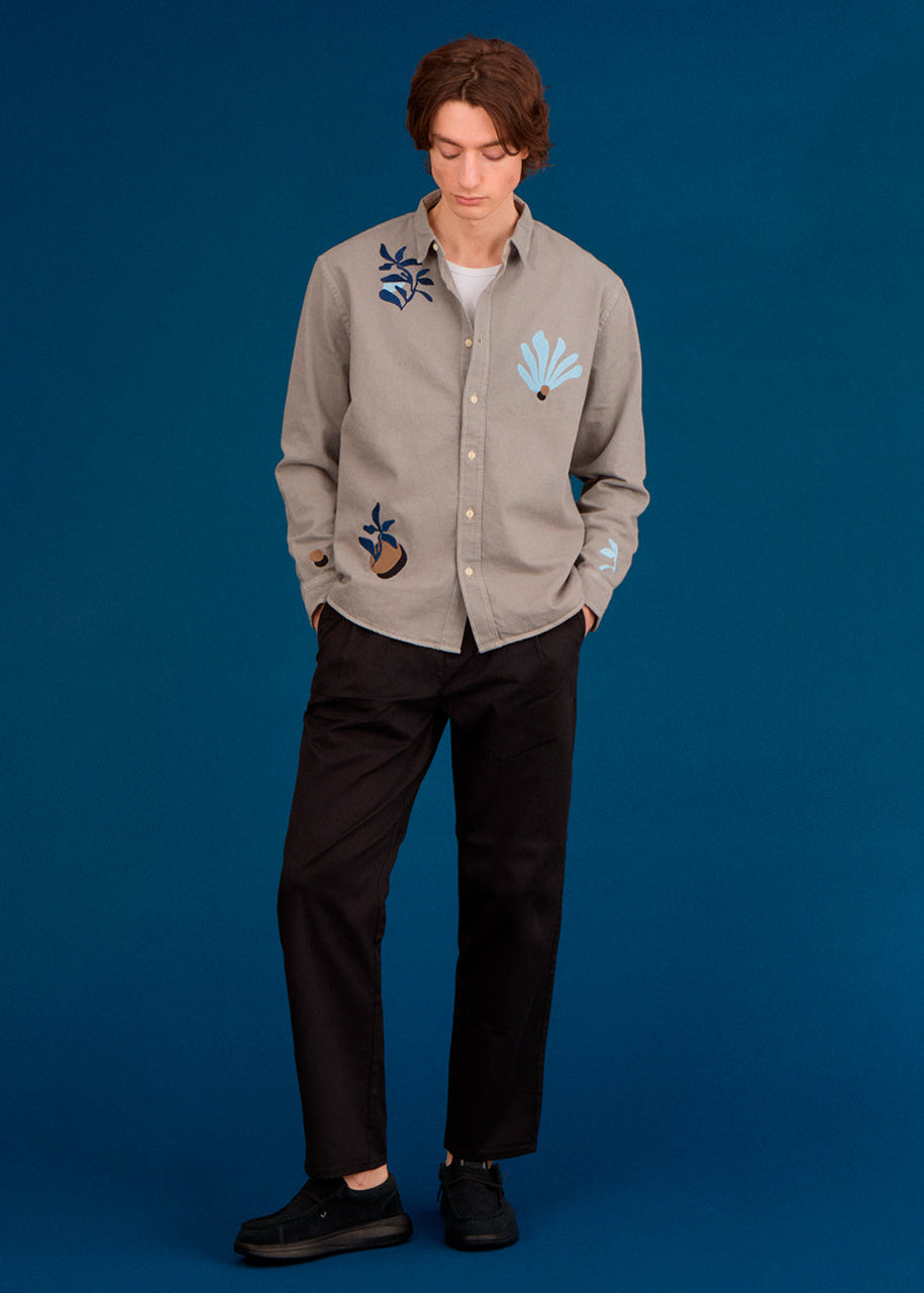 a men wearing an embroidered shirt with abstract floral designs 