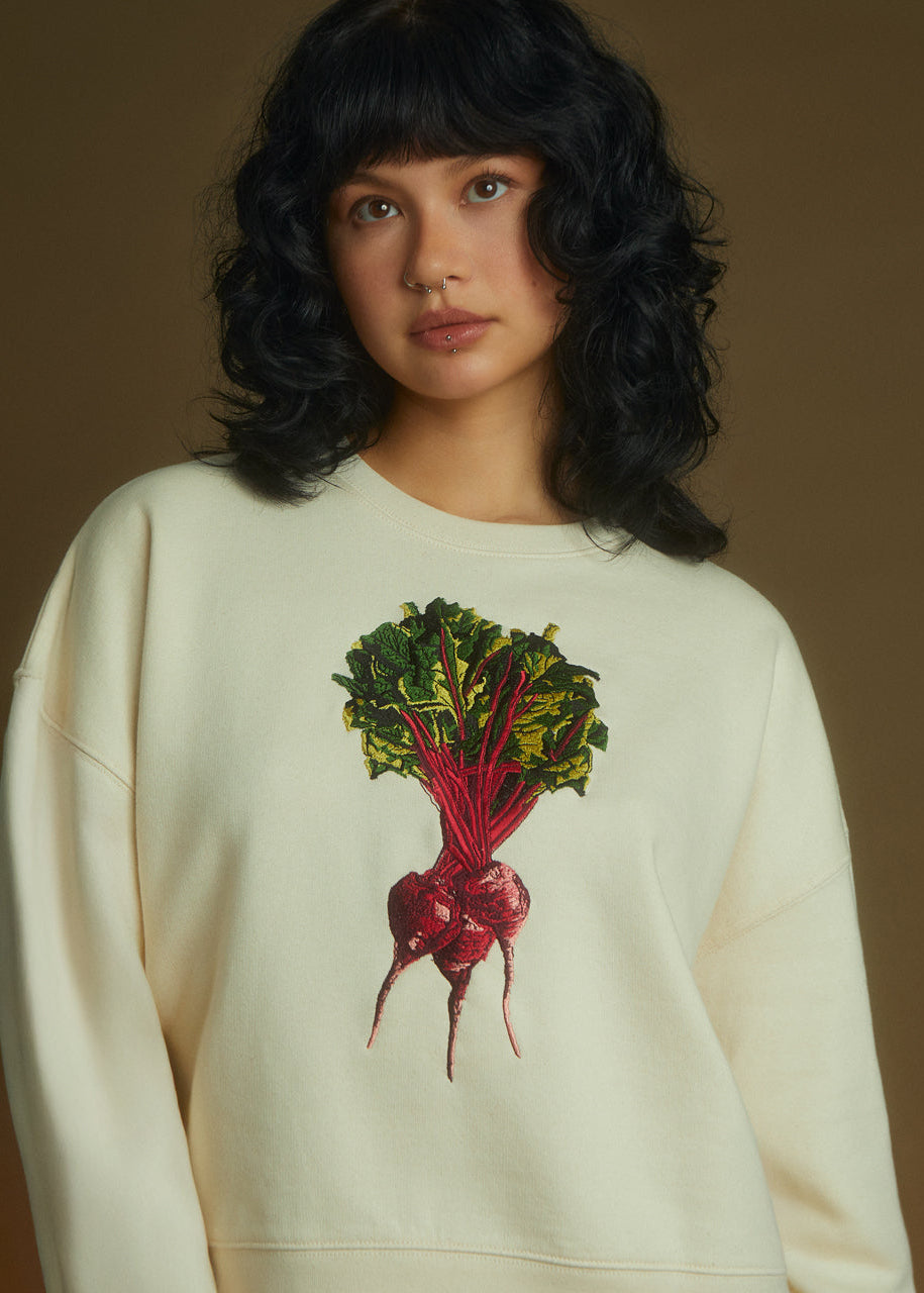 a women wearing a sweatshirt with beetroot embrodiery