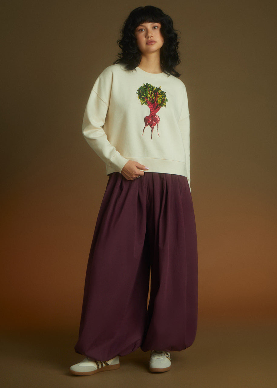 a women wearing a sweatshirt with beetroot embrodiery