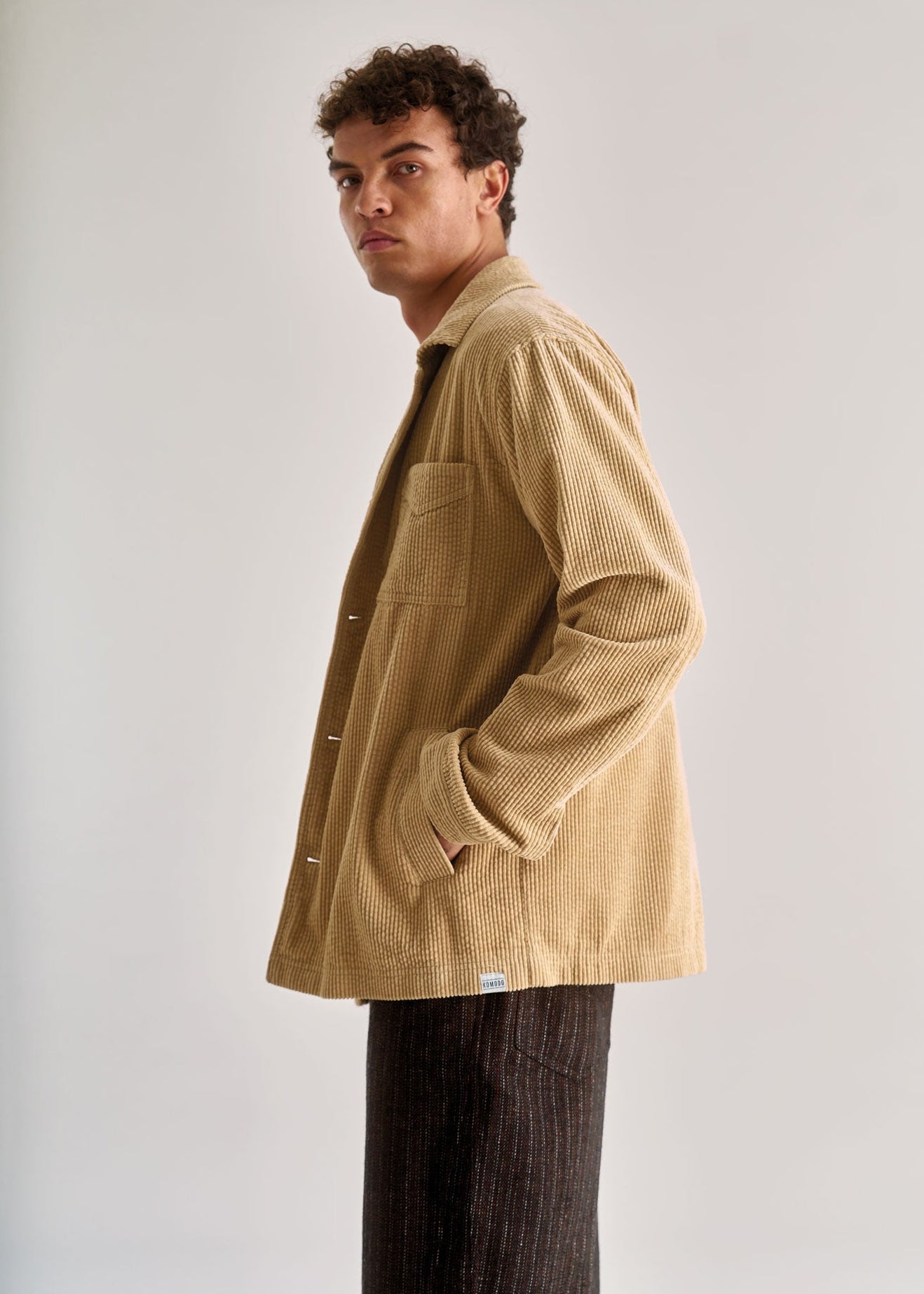 Man wearing a beige corduroy jacket against a plain background