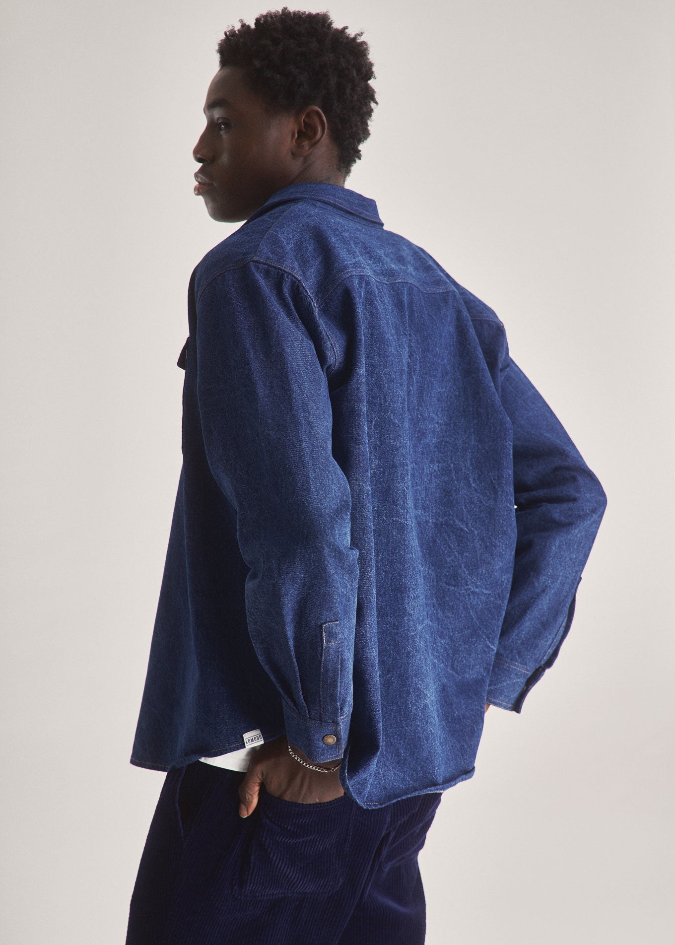 Person wearing a blue textured shirt against a plain background