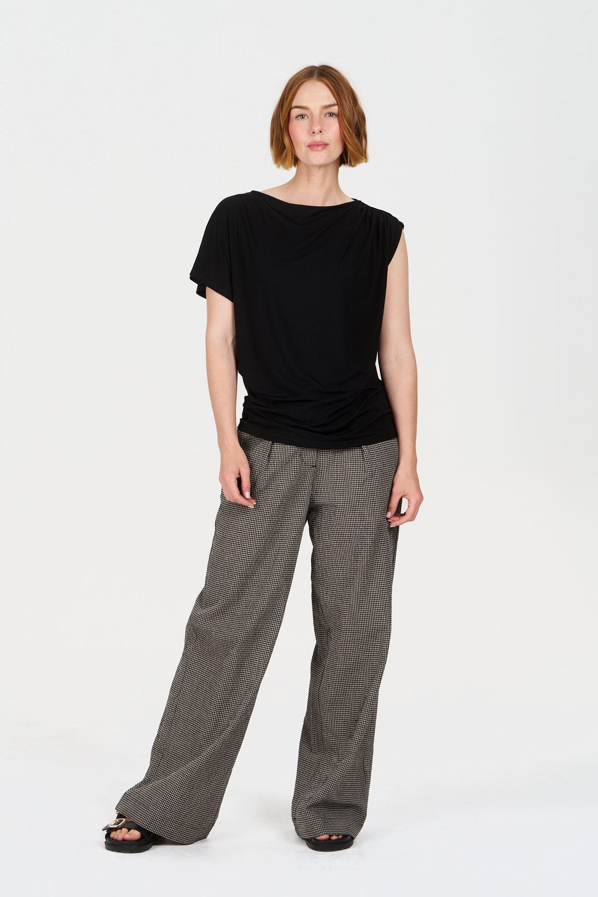Model wearing LOLA Organic Cotton Trouser - check with black top, showcasing eco-friendly fashion style.