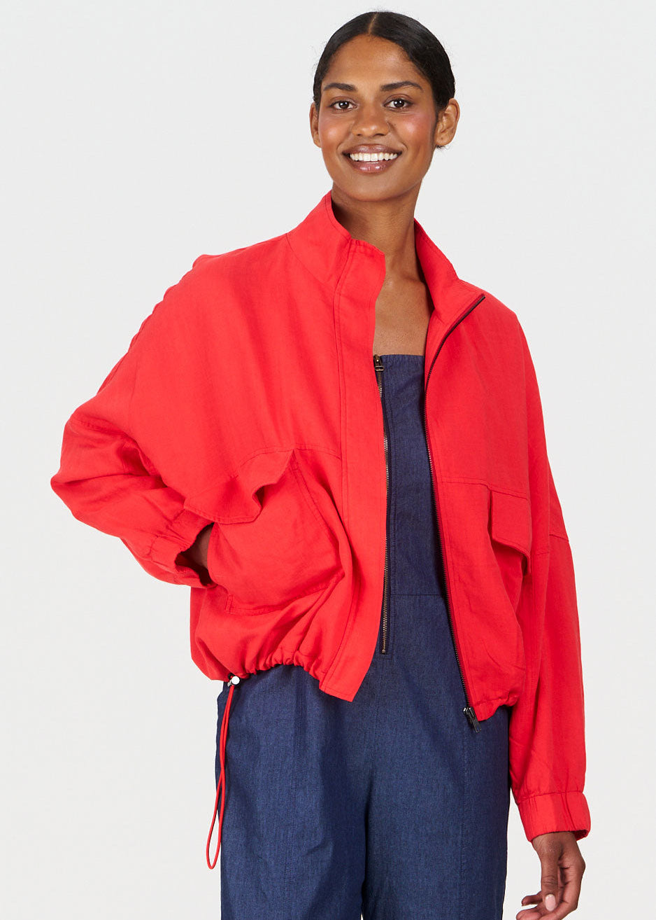 Woman wearing a red jacket over a blue outfit on a white background