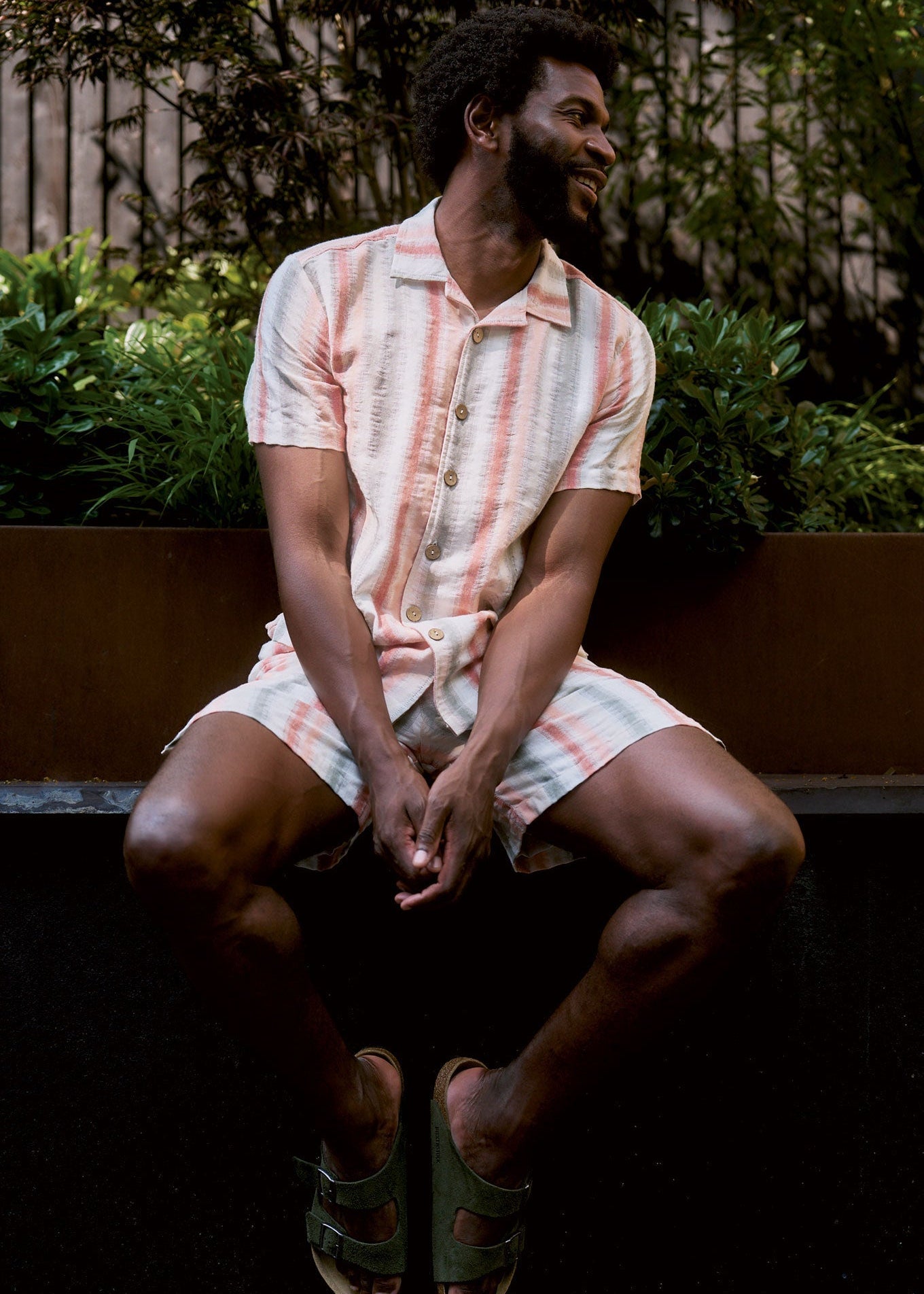 WAVE Organic Cotton Shirt worn by a man sitting in a garden, highlighting its stylish design and breathable fabric.