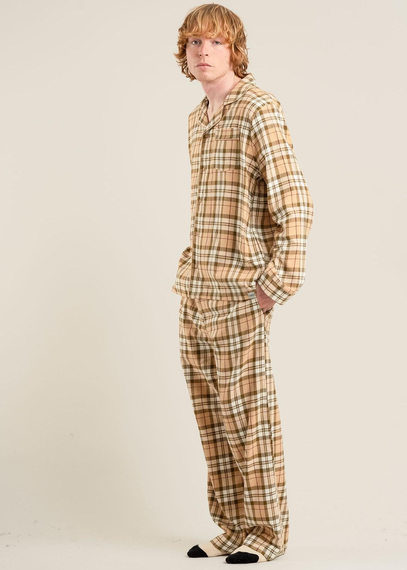 Person wearing a plaid pajama set on a plain background