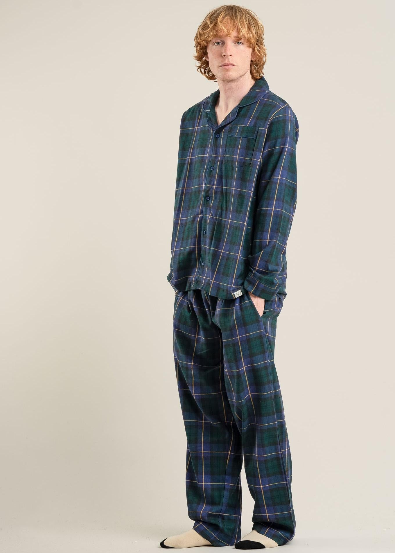 Man wearing a plaid pajama set on a plain background