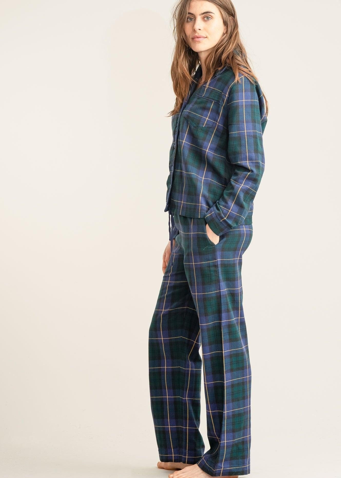 Woman wearing a plaid pajama set on a plain background
