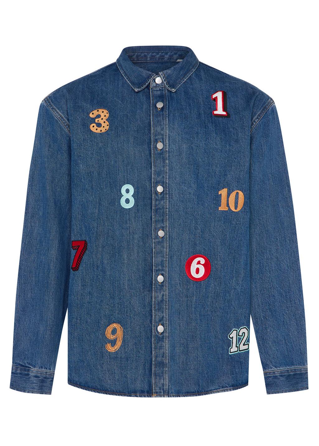 A man wearing a denim shirt with numbers embroidered 