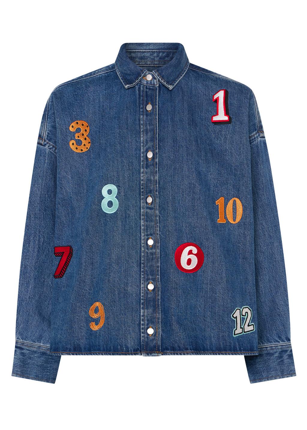 A women wearing a denim shirt with numbers embroidered 