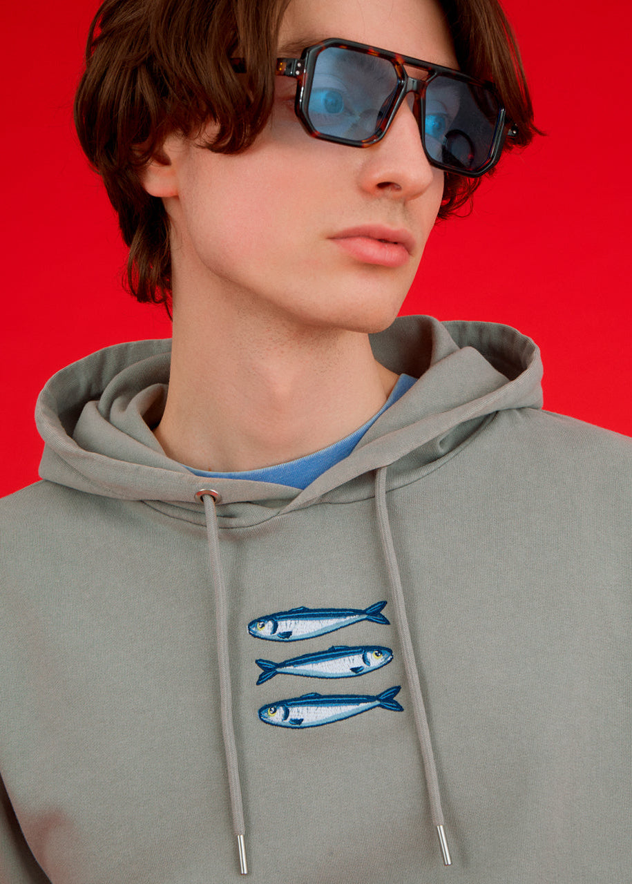 a man wearing an ingmarson hoodie with sardines embroidered  