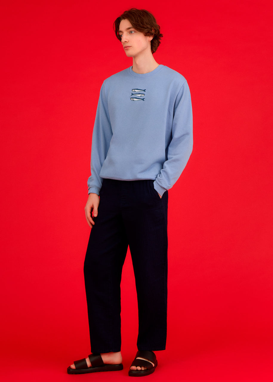 a man wearing a blue ingmarson sweatshirt with sardines embroidered 