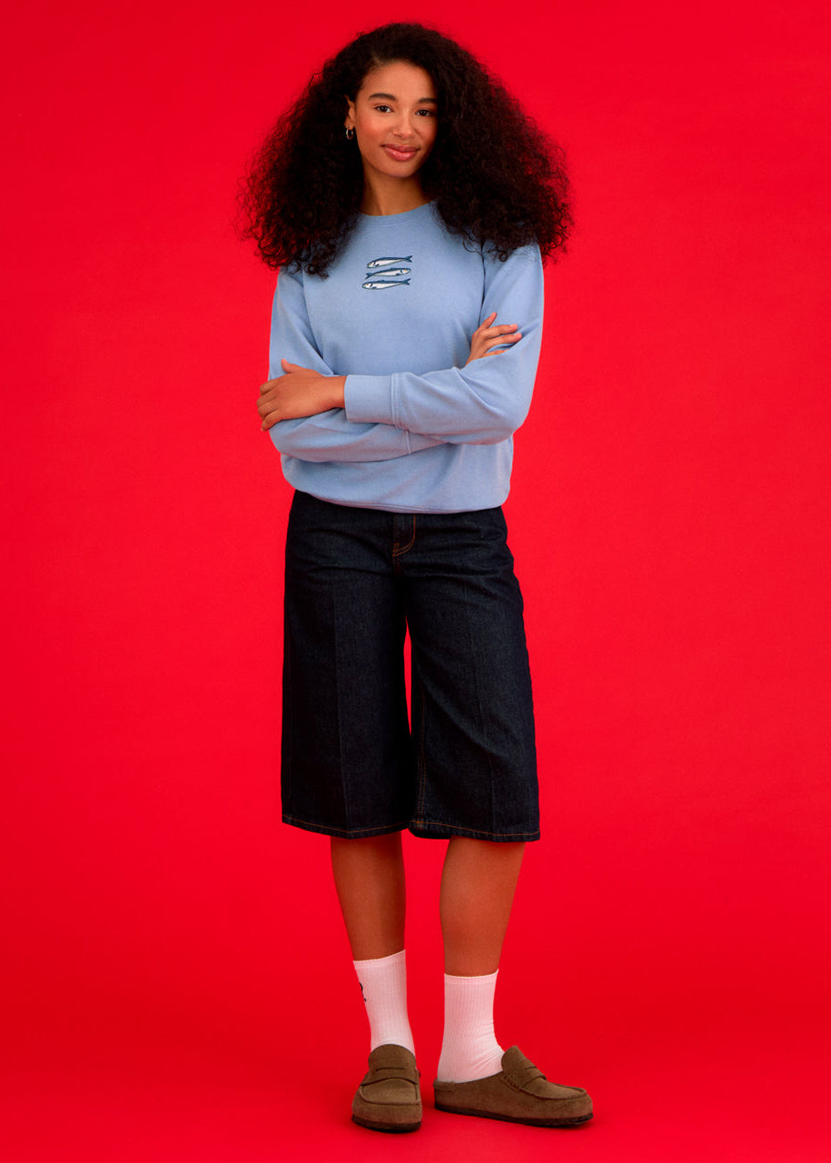 a women wearing a blue ingmarson sweatshirt with sardines embroidered 