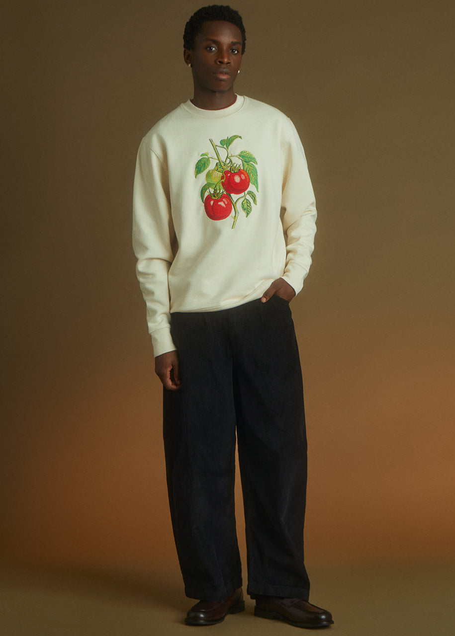a man wearing a sweatshirt with an embroidered tomato