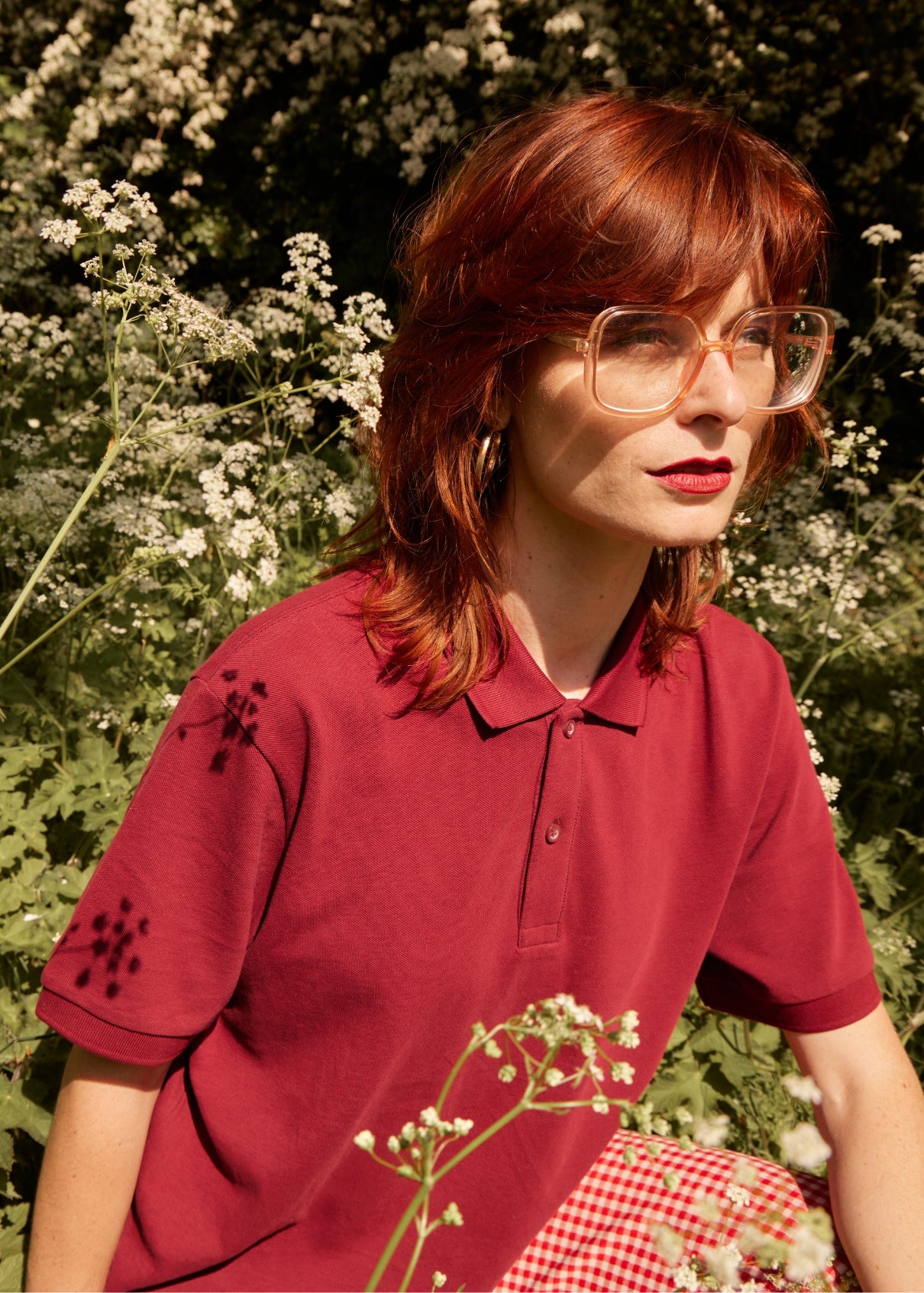 Person wearing a red polo shirt with floral patterns outdoors